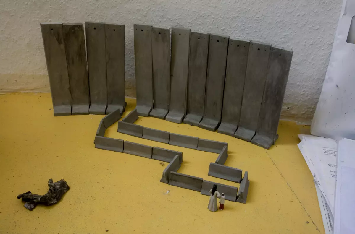 A scaled model of two figurines outside a formation of concrete barricades.