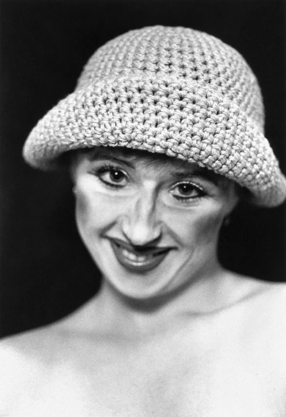 A portrait of a woman with a particular focus on her crocheted hat