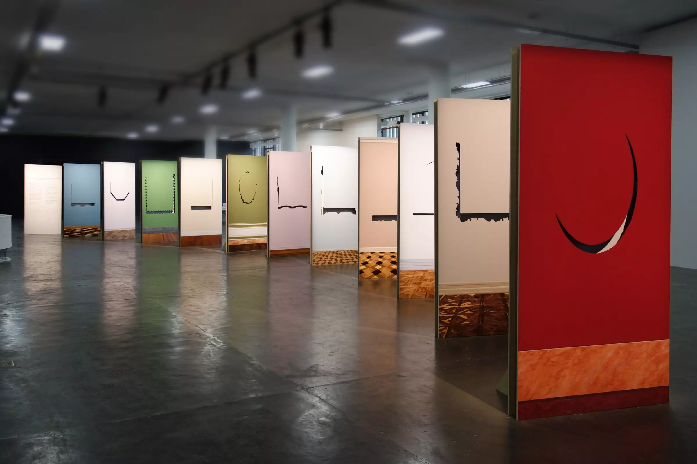 large colored panels standing vertically up like dominoes arranged in a gallery space