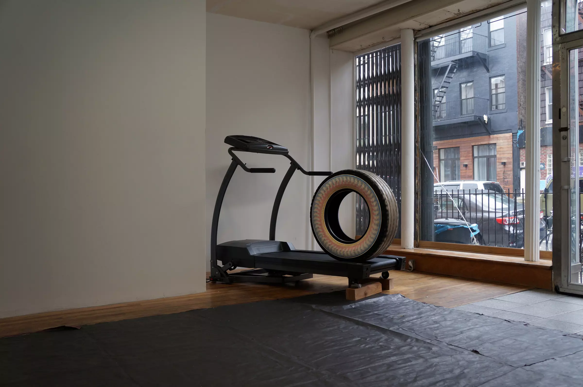 in an empty room a large tire is placed on a treadmill