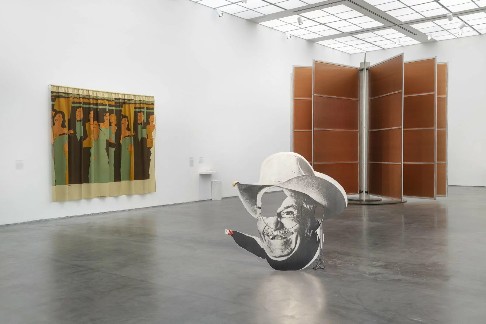 White gallery space with three artworks visible. One is hung on the wall and two are installations.