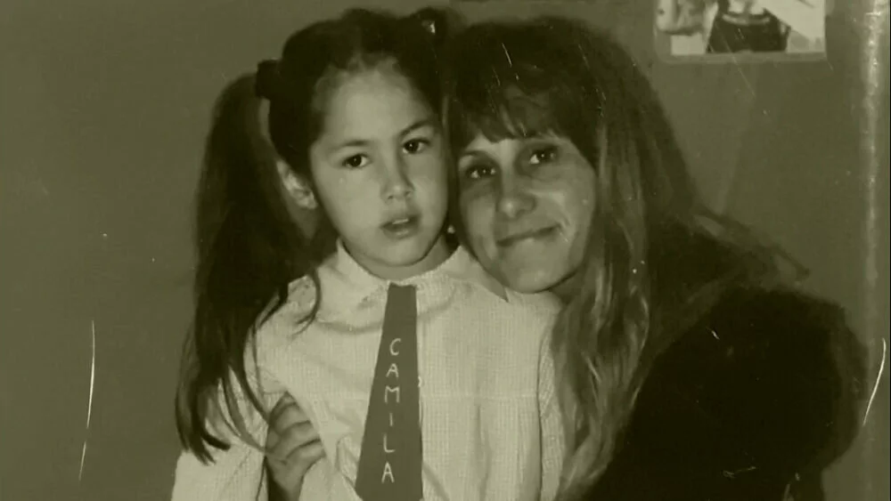 Sepia-toned image of a middle-aged woman with her arm around a young girl