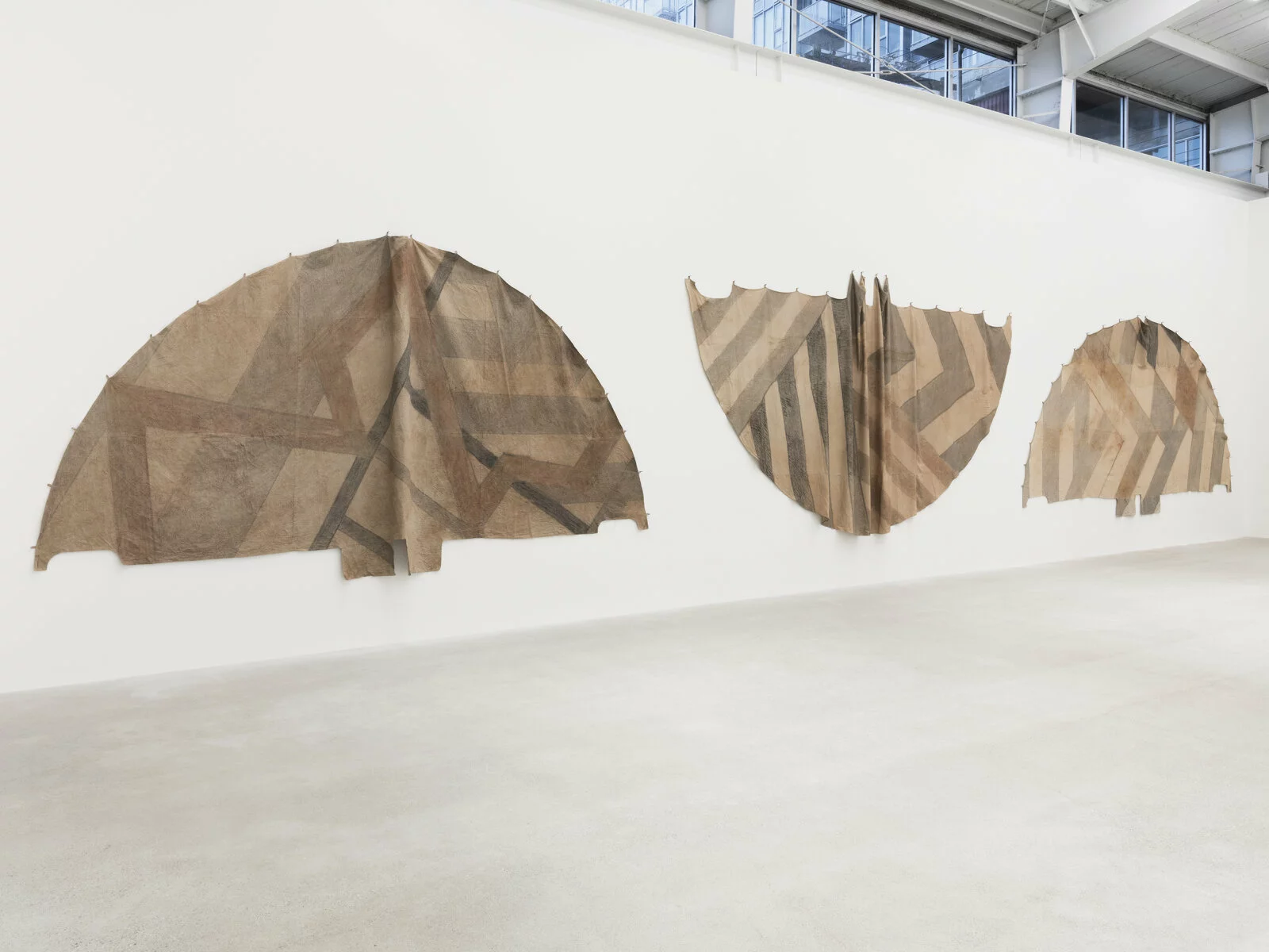 Duane Linklater, Tipi cover for new old geometries, 2018. Digital prints on hand-dyed linen, sumac, cedar, charcoal, nails; dimensions variable. Collection Museum of Contemporary Art Chicago, Gift of Marshall Field’s by exchange, 2023.7. Photo: Rachel Topham Photography. 2022/12/Linklater_3-tipi-covers-for-unknown-future-horizons_2018_Unexplained-Parade_CJ_Apr-10_2019_install_02.jpg 