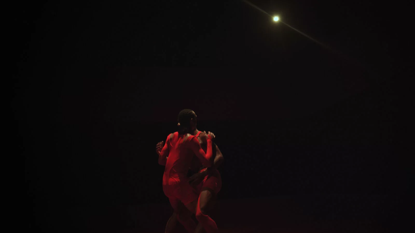 Two performers in a dark room.