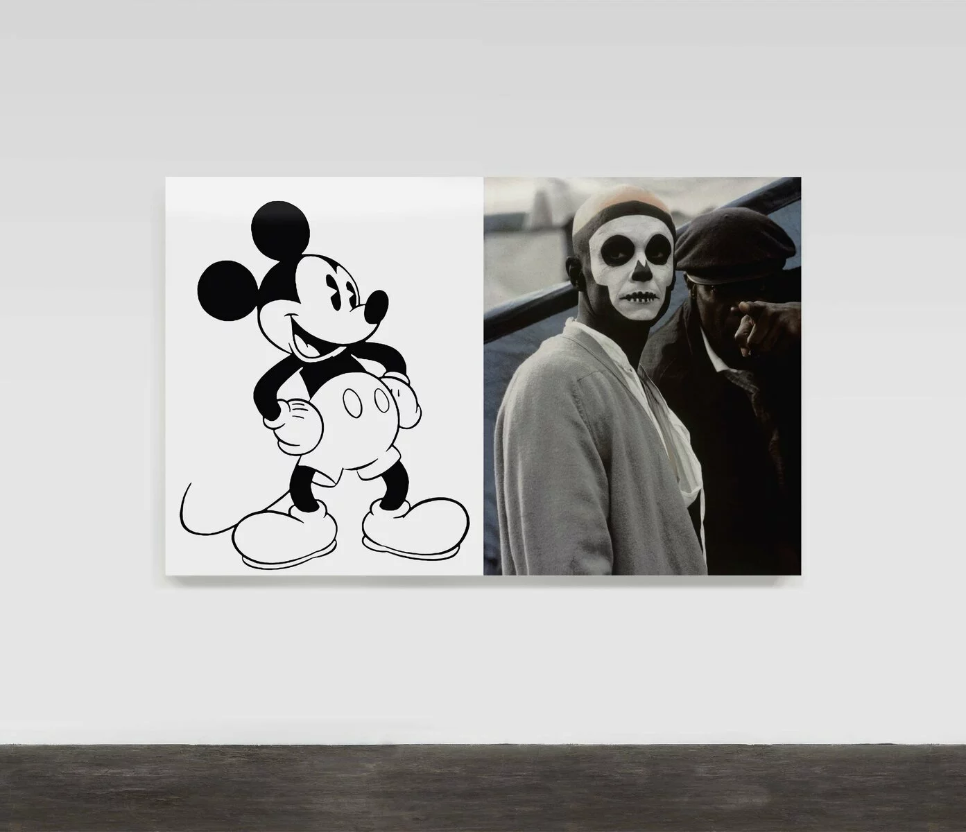 Artwork installed on a white wall. The left side of the artwork is a black and white illustration of Mickey Mouse. The right side of the artwork is a black and white photo of a person with skull makeup on their face.