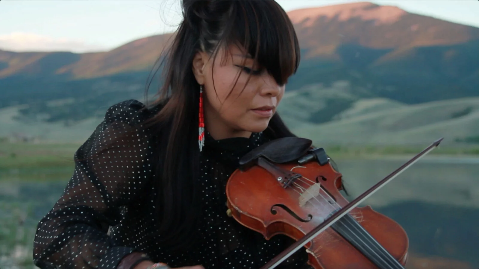 Close up of woman playing violin outdoors