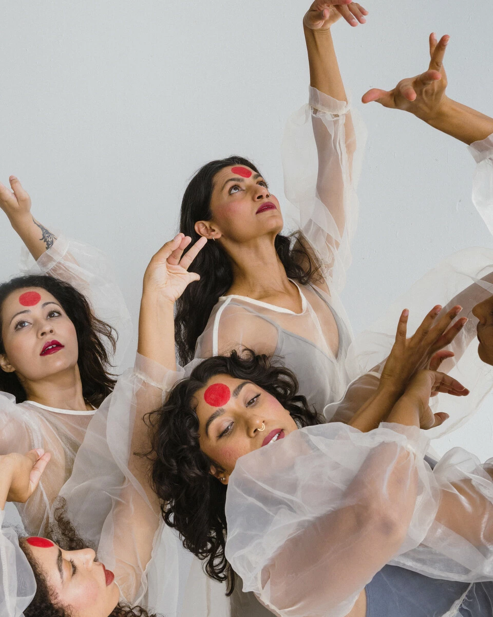 A close up view of dancers' faces, and arms.