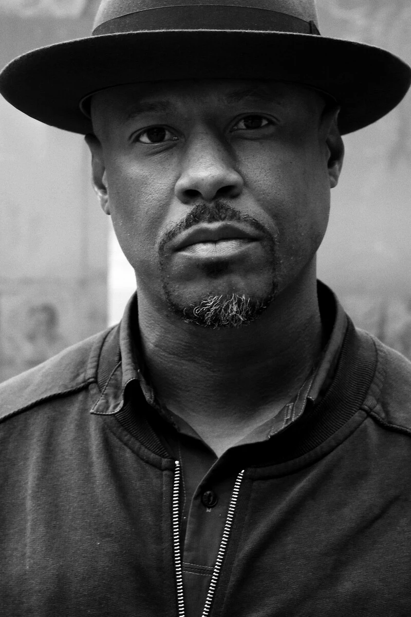 Black and white portrait of a man with dark skin wearing a hat