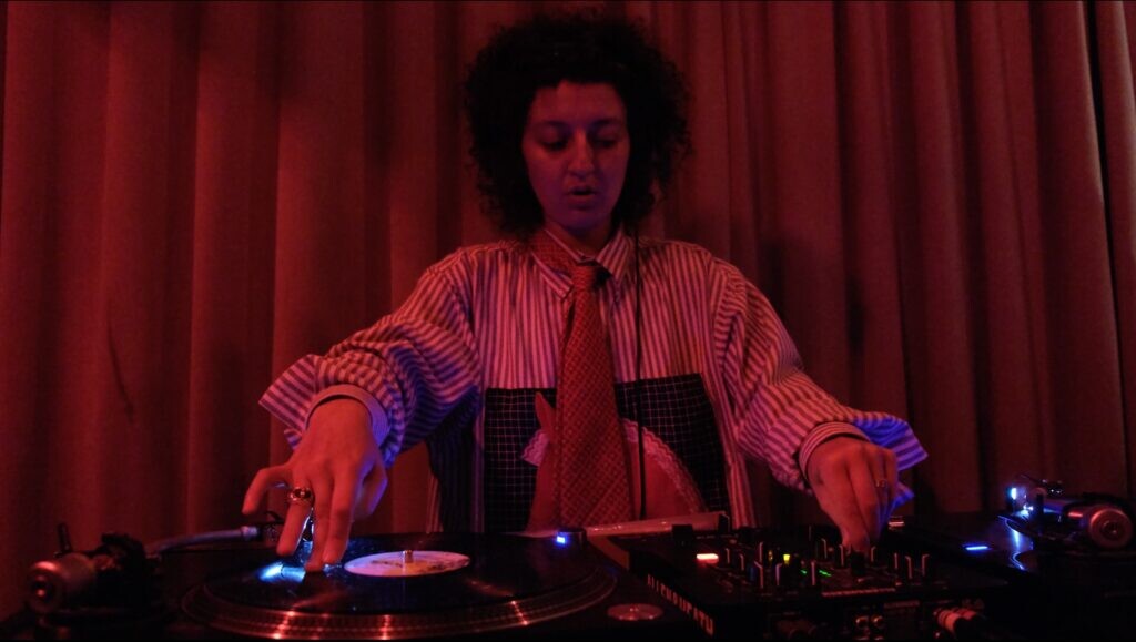 Red toned image of a person spinning records