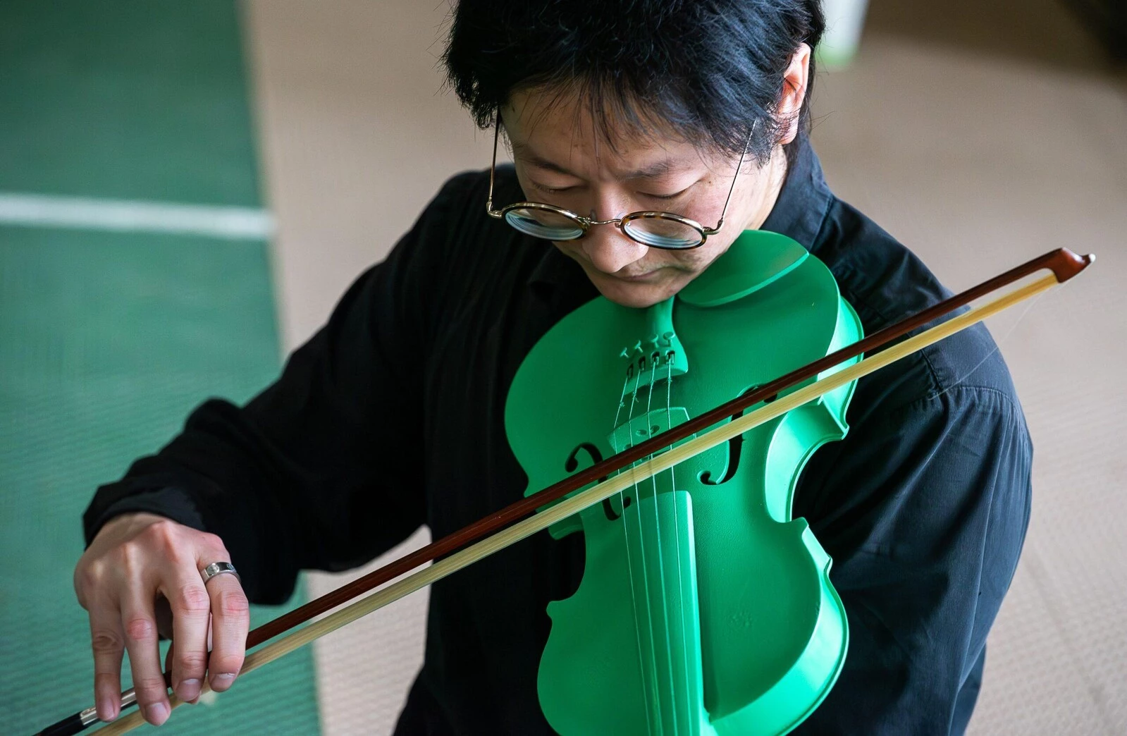 Close up of a person playing a green violin