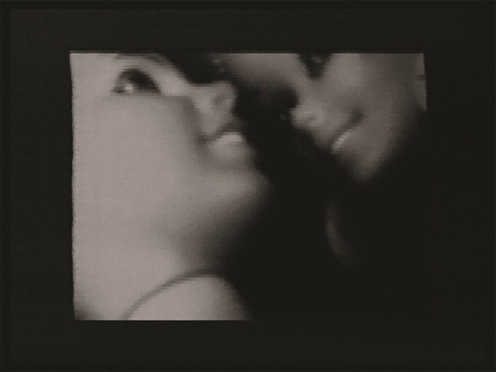 Black and white close up of two dolls' heads framed in black