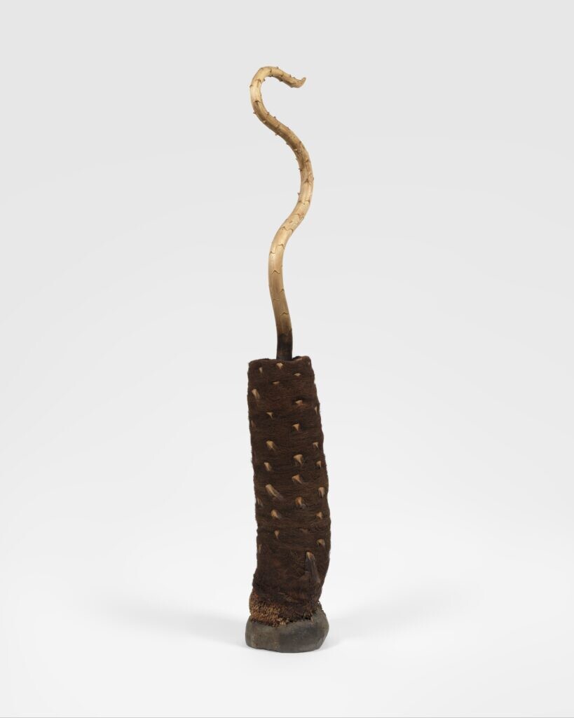 A gold snake like object sticking out of a piece of lumber